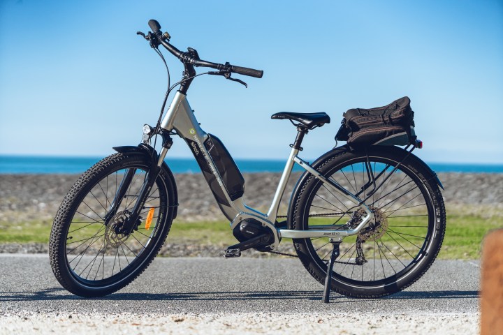 Electric bicycle parked on a path with ocean and sky in background.
